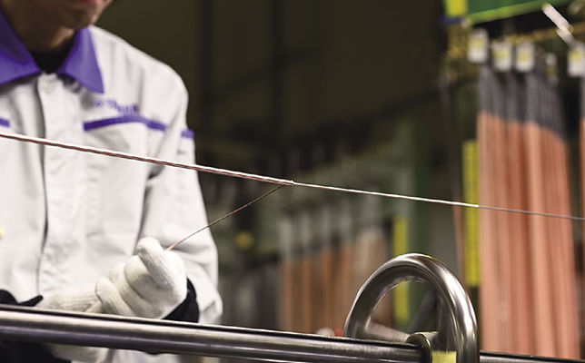 芯となる鉄線に純度の高い銅線を巻きつけているところ