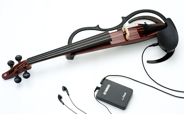 演奏時に周囲に聞こえる音量を抑えながら、イヤフォンから自然なバイオリンの音色を楽しめる。コントロールボックス（写真手前）のスイッチ操作で、はっきりとした音色で短めのリバーブの「ROOM」、柔らかい音色で長めのリバーブの「HALL」の2種類のサウンドタイプを選べる。